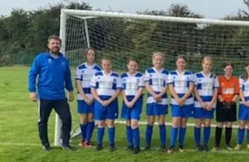 Local girls football team proudly wearing sponsored kits supported by Britcon during a community sports initiative.