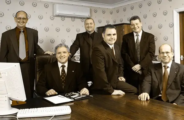 A group portrait of the Britcon founding family gathered in one of the original office spaces.